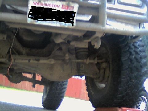 1987 Ford Bronco II - Undercarriage of a lifted 4x4 vehicle, showing suspension and large tires.