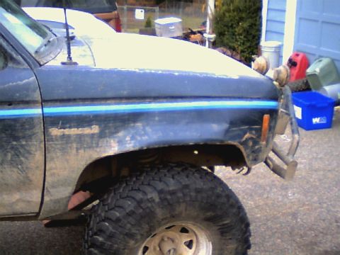 1987 Ford Bronco II - This 1987 Ford Bronco II shows significant mud coverage and a two-tone stripe on the fender.