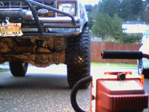 1987 Ford Bronco II - The front end of a lifted 1987 Ford Bronco II is shown with a winch and brush guard, parked outdoors.