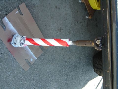 1989 Ford Bronco - A driveshaft, wrapped in red and white tape, is shown attached to the frame of a vehicle.