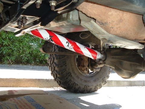 1989 Ford Bronco - Undercarriage view shows a painted suspension part and a large off-road tire.