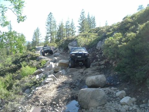 1989 Ford Bronco - Off-road vehicles tackle a challenging rocky path during an outdoor adventure.