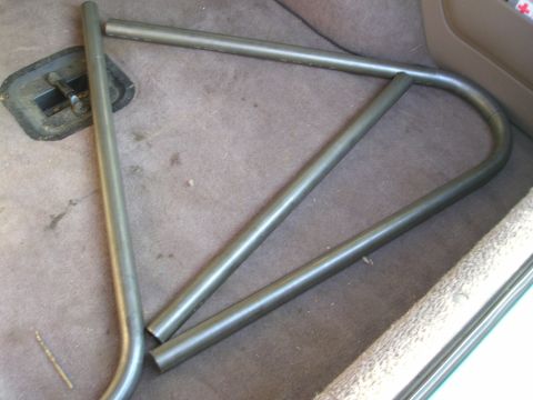 1996 Ford Bronco - Metal tubing, likely for a roll cage, is placed inside a vehicle's interior.