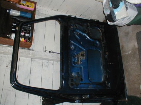 1979 Ford Bronco - A detached vehicle door is shown, with its interior components exposed and mounted against a wooden wall.