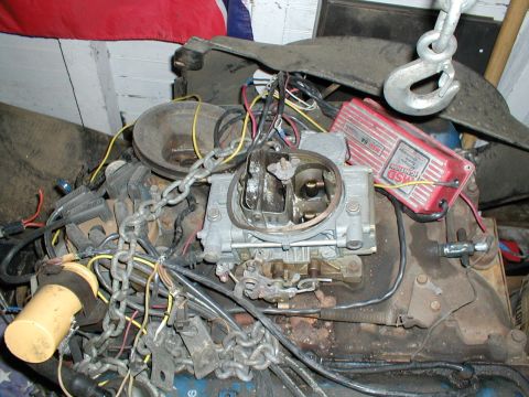 1979 Ford Bronco - Engine components including a carburetor and an MSD ignition box are shown, held by chains.
