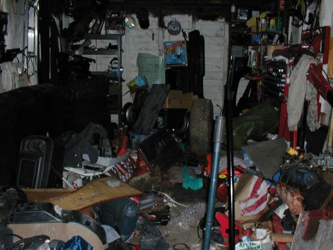 1979 Ford Bronco - A disorganized garage scene filled with various items, including tires, tools, and shelving units.