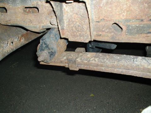 1979 Ford Bronco - Close-up of a rusted leaf spring and frame component on a vehicle.