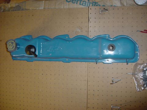 1989 Ford Bronco - Blue Ford valve cover with oil cap and dipstick tube hole is shown on a pegboard.