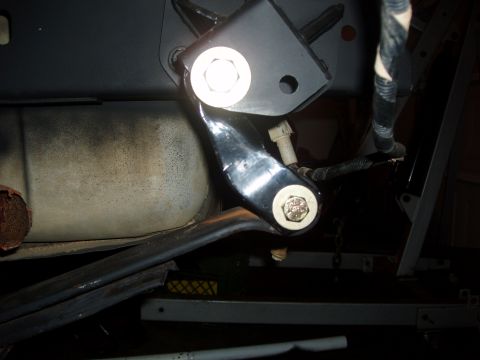 1994 Ford Bronco - A close-up view of a vehicle's undercarriage, focusing on a metal bracket and bolt assembly.