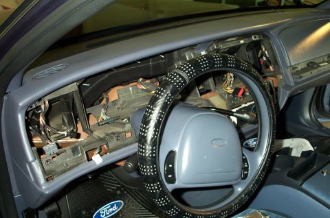 1998 Ford Crown Victoria - The dashboard of a car is partially disassembled, revealing wiring and internal components.