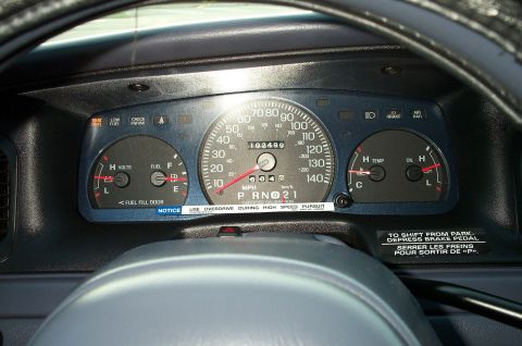 1998 Ford Crown Victoria - Close-up of a custom gauge cluster trim panel, a speedometer, fuel gauge, temperature gauge, and oil gauge.