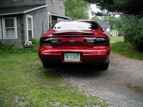 1997 Ford Taurus - Rear view of a red 1997 Ford Taurus with a spoiler and tinted taillights.