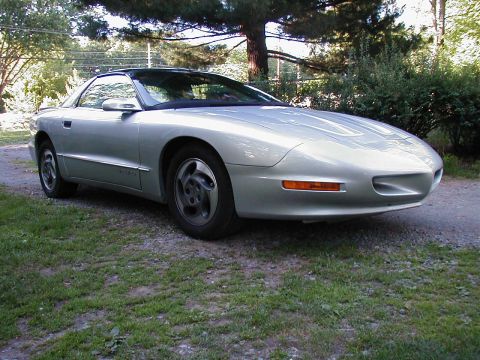 1997 Ford Taurus - This silver coupe with a black roof is parked on a gravel driveway.