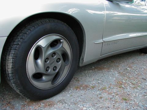 1997 Ford Taurus - Side view of a silver car, identified by the 'FIREBIRD' emblem on the door and a distinctive alloy wheel.