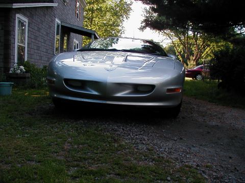 1997 Ford Taurus - Front view of a silver Pontiac Firebird parked outside a house, with another car visible in the background.