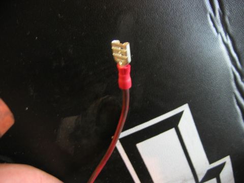 1985 Ford Crown Victoria LTD - A single electrical spade connector with a red wire is shown against a black textured background.