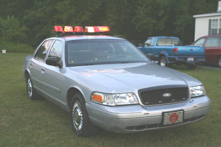 Silver 1998 Ford Crown Victoria police car with light bar
