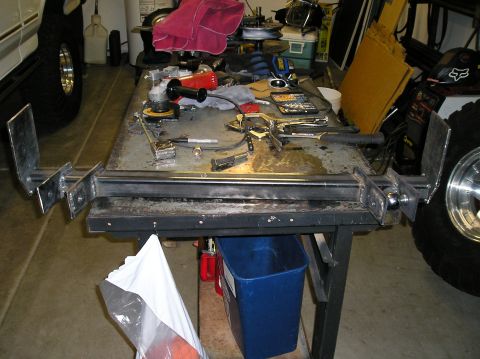 1993 Ford Bronco - Metal fabrication parts are laid out on a workbench with tools and a grinder, ready for assembly.