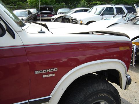 1986 Ford Bronco - Front quarter view of a damaged 1986 Ford Bronco XLT, showing the 'Bronco XLT' badge.
