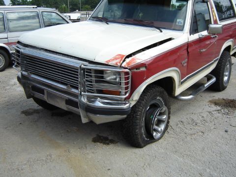 1986 Ford Bronco - This Ford Bronco has a flat tire and some front-end damage.
