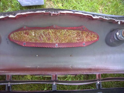 1997 Ford Taurus - The interior of a car bumper shows a red mesh covering an opening, with grass visible in the background.