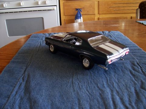 1995 Ford Bronco - Model car with racing stripes sits on a blue cloth on a wooden table.