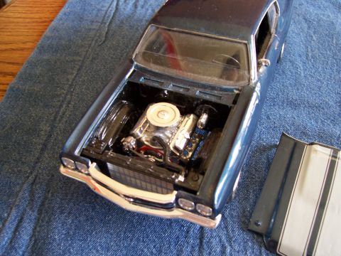 1995 Ford Bronco - A detailed model car displays its engine compartment with the hood removed and placed nearby.