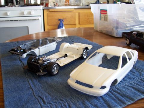 1995 Ford Bronco - Model car parts are laid out on a blue cloth, ready for assembly, with a kitchen in the background.