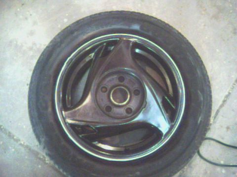 1990 Ford Probe - A single chrome alloy wheel with a tire is shown against a concrete surface.