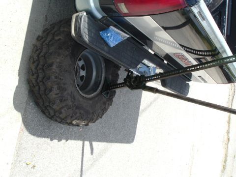1989 Ford Bronco - A high-lift jack is being used to lift the rear tire of a GMC truck.