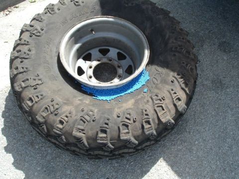 1989 Ford Bronco - Off-road tire and rim with blue beads spilled inside.