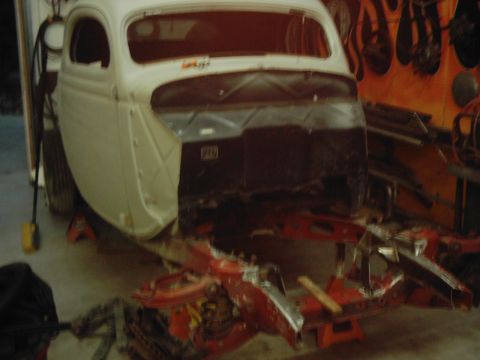 1978 Ford Bronco - This vintage car body, likely from 1936, is shown in a state of repair or modification, mounted on a red stand.