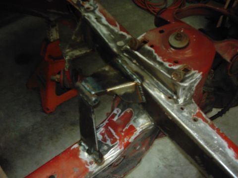 1978 Ford Bronco - Close-up of vehicle frame undergoing welding and repair work, supported by jack stands.