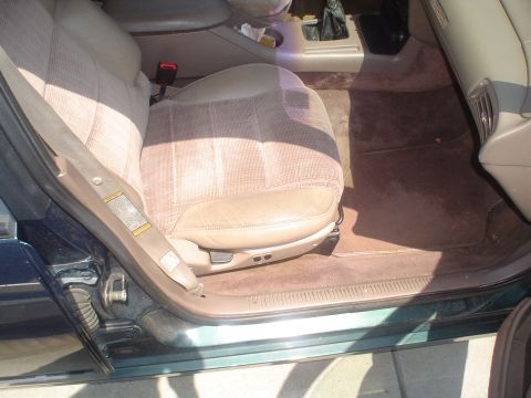 1995 Ford Taurus - The interior of a car shows fabric and leather seats, the door panel, and the center console area.