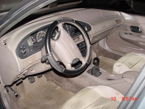 1995 Ford Taurus - The interior of a 1995 Ford Taurus, showing the dashboard, steering wheel, and front seats.