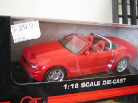 1990 Ford Bronco - red Ford Mustang convertible 1:18 scale die-cast model in a window box with a $29.95 price sticker.