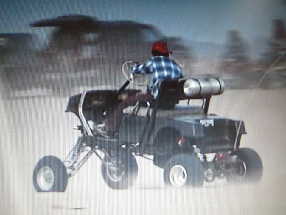 Rear view of rider on tube-frame sand buggy with rear tank