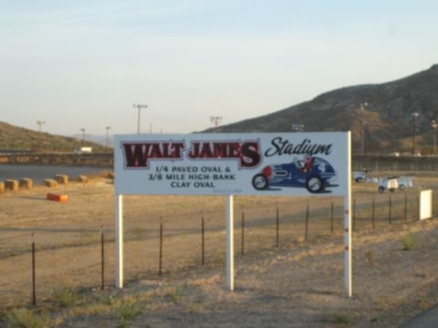 1990 Ford Bronco - trackside sign for Walt James Stadium advertising a quarter-mile paved oval and high-bank clay oval with sprint-car art.