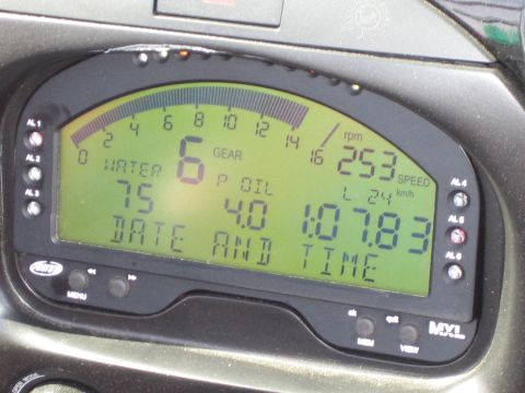 1990 Ford Bronco - Close-up of an AIM MXL digital race dash showing a shift-light RPM bar, gear, water and oil readouts.