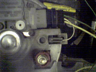 1990 Ford Bronco - Close-up view of electrical connections on an alternator, with a yellow warning label visible.