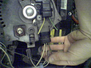 1990 Ford Bronco - Close-up of alternator wiring being connected, with Supermotors.net watermark.