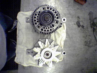 1990 Ford Bronco - Comparison of two different automotive alternators, likely for a repair or upgrade.
