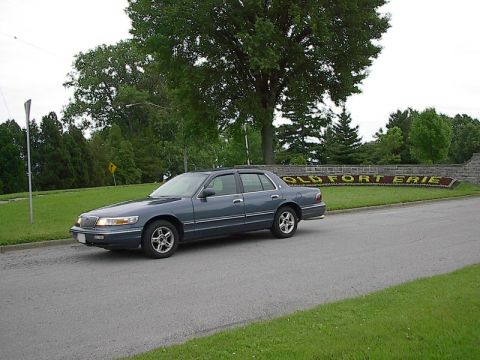 1985 Mercury Grand Marquis - Blue Mercury Grand Marquis parked near the "OLD FORT ERIE" sign.