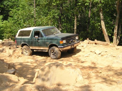 1996 Ford Bronco - A green 1992 Ford Bronco navigates a rocky off-road trail.