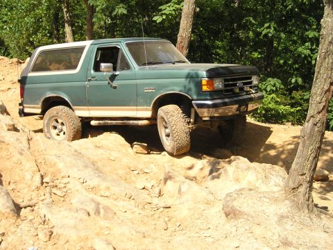 1996 Ford Bronco - 1996 Ford Bronco tackling rough terrain on an off-road trail.