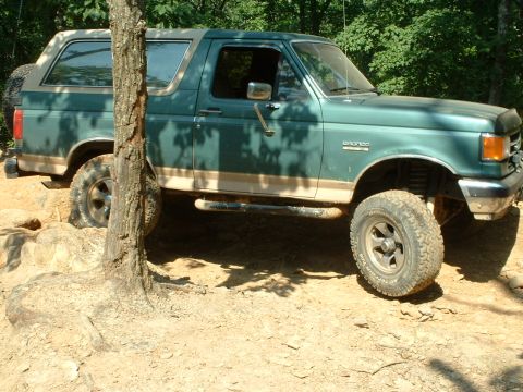 1985 Ford Bronco - This Ford Bronco is navigating a rocky, wooded trail.