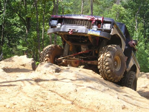 1996 Ford Bronco - This heavily modified truck is navigating a challenging rocky terrain.