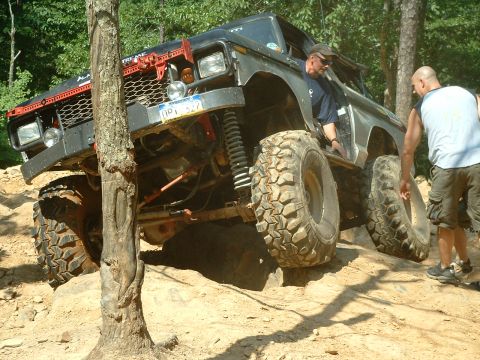 1985 Ford Bronco - This 1985 Ford Bronco navigates a challenging off-road course with two people observing.