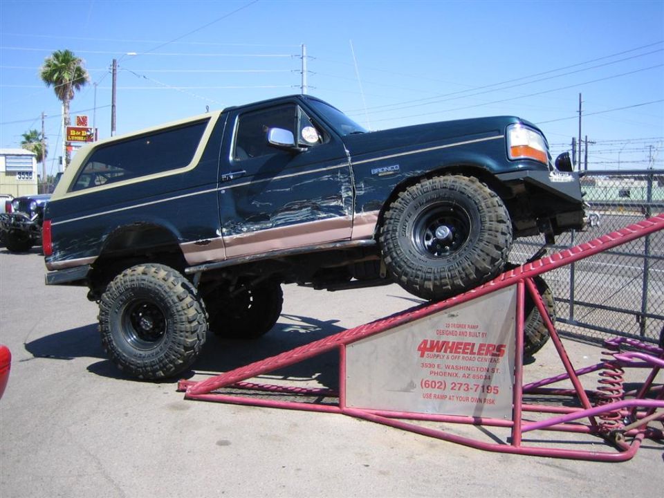 1994 Ford Bronco on a ramp, dark green with tan top
