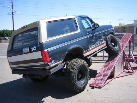 1994 Ford Bronco - Ford Bronco on a ramp, showing off its lifted suspension and off-road tires.